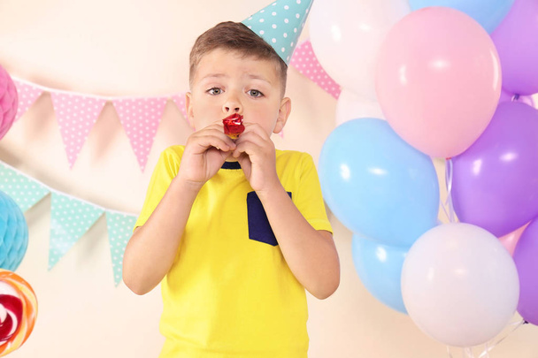 Χαριτωμένο μικρό αγόρι με κόμμα σφύριγμα έχουν γενέθλια στο σπίτι - Φωτογραφία, εικόνα