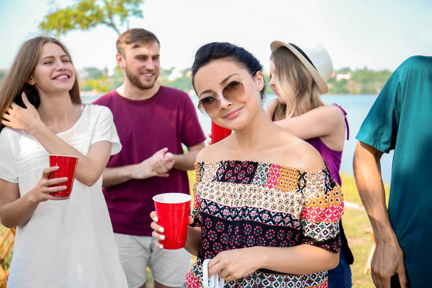 Νέοι άνθρωποι έχοντας μπάρμπεκιου πάρτι στην ηλιόλουστη ημέρα σε εξωτερικούς χώρους - Φωτογραφία, εικόνα