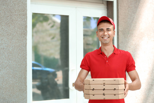 Young man with pizza boxes outdoors. Food delivery service - Foto, Bild