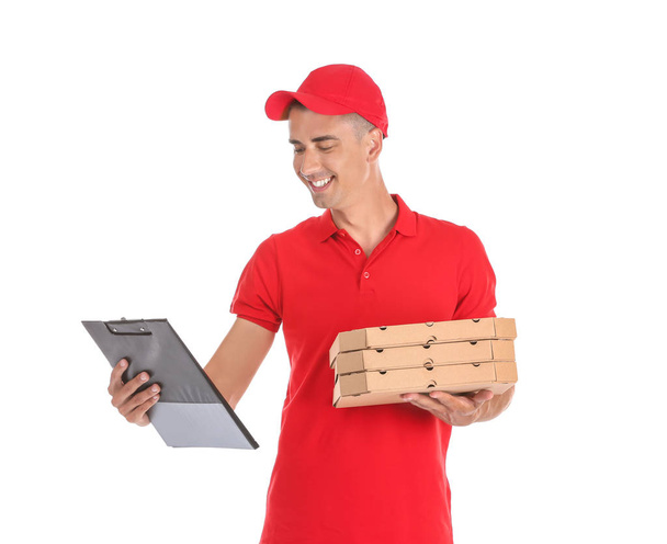 Νεαρός άνδρας με κουτιά πίτσας και πρόχειρο σε άσπρο φόντο. Υπηρεσία παράδοσης τροφίμων - Φωτογραφία, εικόνα