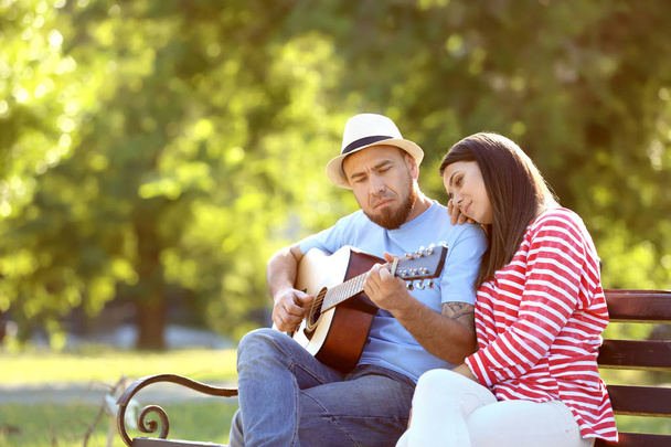Boldog pár gitár pihenő parkban a tavasz - Fotó, kép