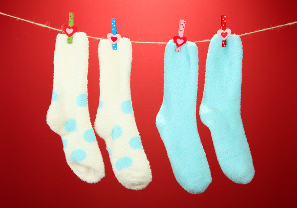 Colorful socks hanging on clothesline, on color background - Foto, imagen