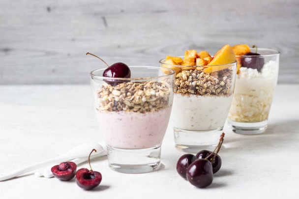 Yogurt with granola and fruit on a white background. Diet dessert. - Photo, image
