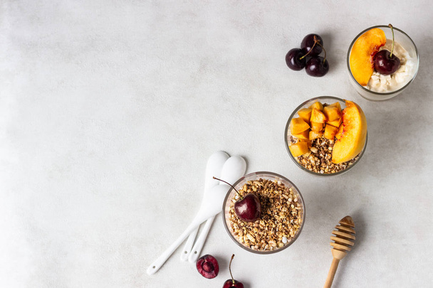 Yogurt with granola and fruit on a white background. Diet dessert. - Valokuva, kuva