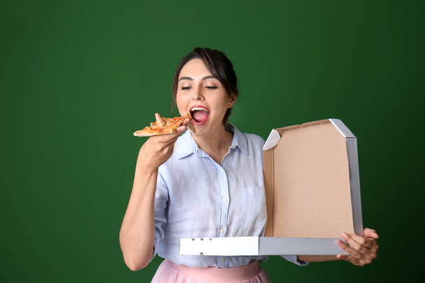 Attractive young woman with delicious pizza on color background - Фото, изображение