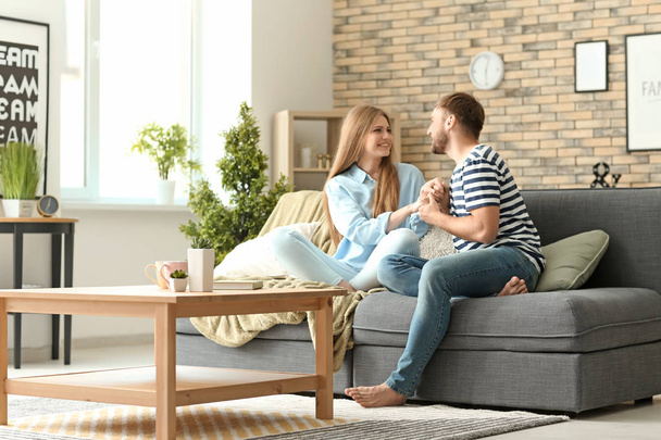 glückliches junges Paar ruht sich zu Hause auf dem Sofa aus - Foto, Bild