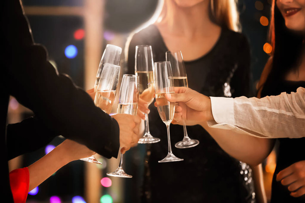 Молодые люди звонят в бокалы с шампанским на дне рождения в клубе
 - Фото, изображение