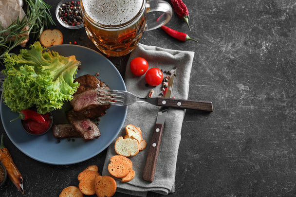 Izgara biftek ve baharat gri tablo ile lezzetli bira kupa - Fotoğraf, Görsel