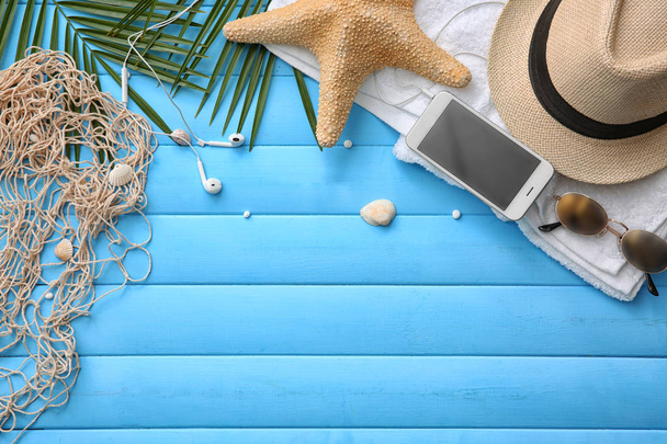 Composition with smartphone and summer accessories on color wooden background - Foto, Imagem