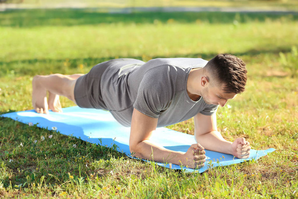 Homme sportif pratiquant le yoga dans le parc
 - Photo, image