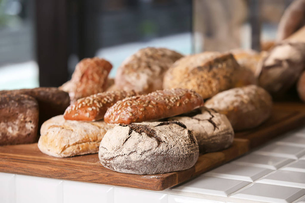 Ассортимент свежего хлеба на стойке в пекарне
 - Фото, изображение