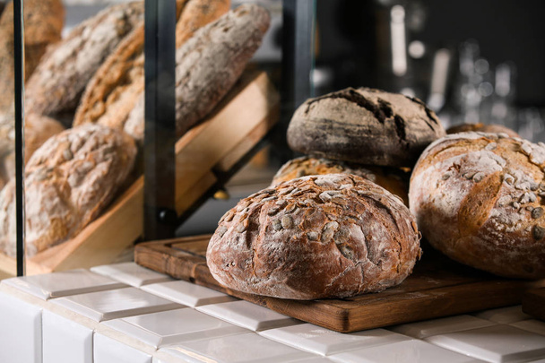 Ассортимент свежего хлеба на стойке в пекарне
 - Фото, изображение