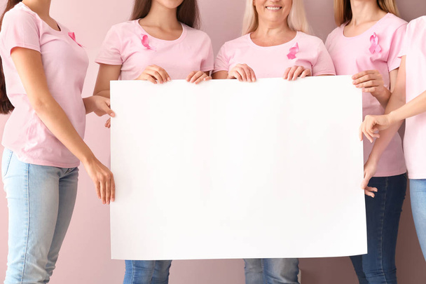 Gyönyörű nők különböző korú gazdaság poszter háttér szín, rózsaszín szalaggal. Mell rák fogalma - Fotó, kép