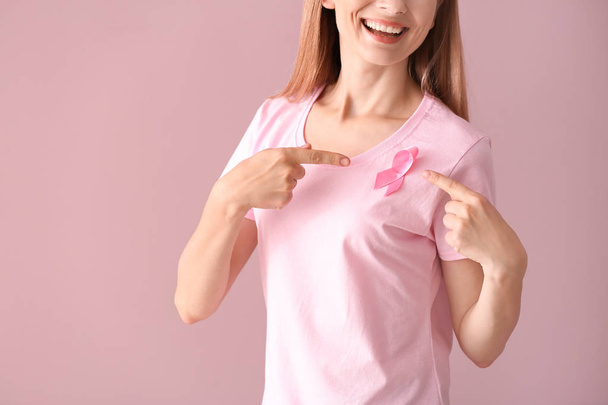 Renk arka plan üzerinde pembe kurdele ile güzel bir kadın. Meme kanseri kavramı - Fotoğraf, Görsel