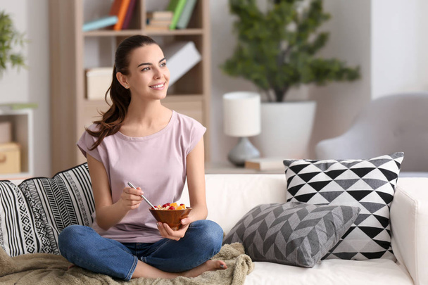 Young woman eating tasty oatmeal at home - Photo, image