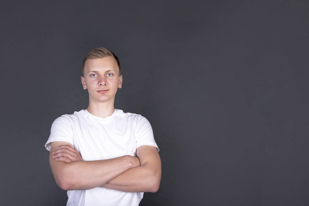 Blond handsome young man with hands crossed on chest looking in camera - Фото, зображення