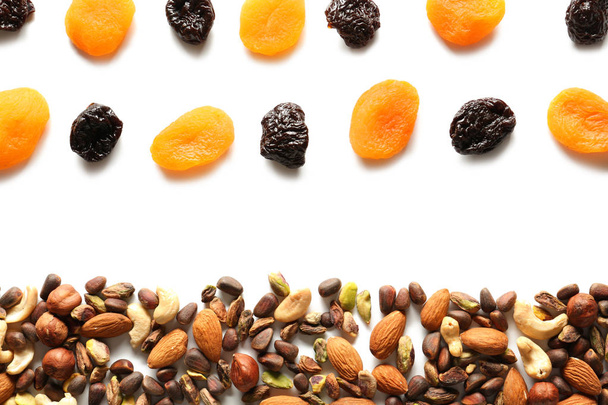 Composition with different nuts and dried fruits on white background - Photo, Image