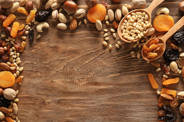 Different nuts and dried fruits on wooden background - Photo, Image