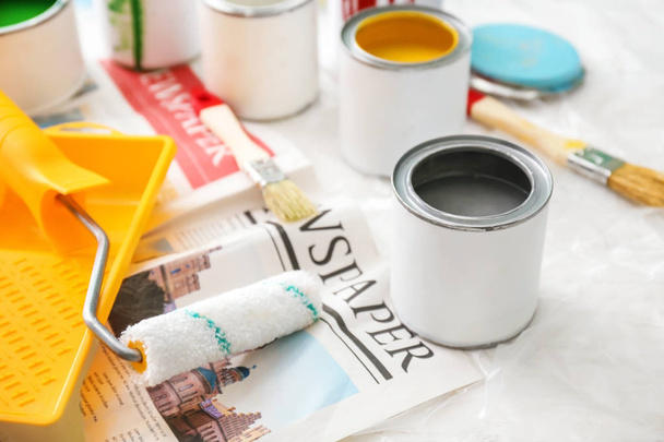 Latas de pintura com ferramentas na mesa
 - Foto, Imagem