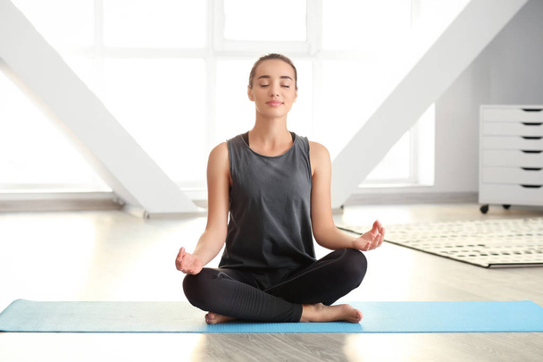 Junge Frau praktiziert Yoga zu Hause - Foto, Bild