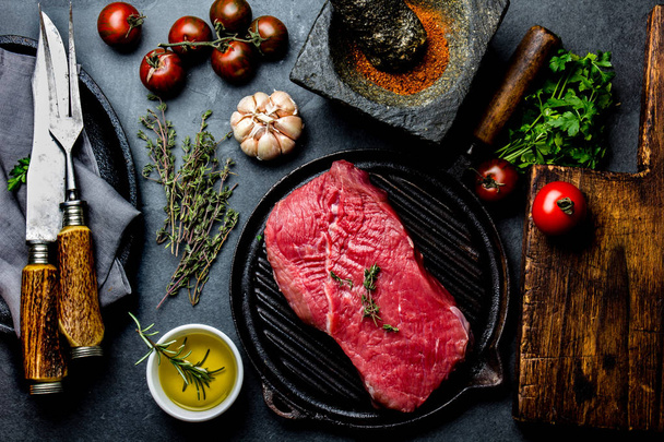 Fresh raw meat steak beef tenderloin, herbs and spices around cutting board. Food cooking background with copy space. - Foto, afbeelding
