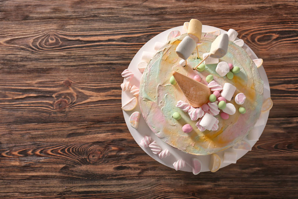 Placa con delicioso pastel de cumpleaños sobre fondo de madera
 - Foto, Imagen