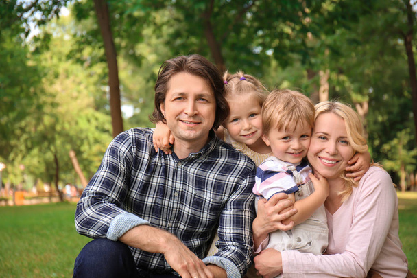 Щаслива сім'я в парку в літній день
 - Фото, зображення