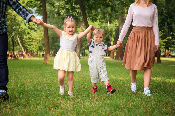 Ευτυχισμένη οικογένεια περπάτημα σε καταπράσινο πάρκο - Φωτογραφία, εικόνα