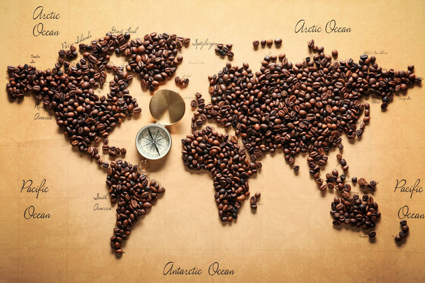 Карта мира из жареных кофейных зерен с компасом, вид сверху
 - Фото, изображение