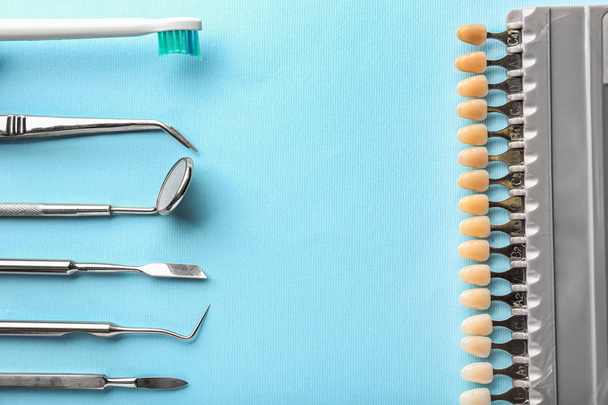 Стоматологические инструменты с образцами зубов и щеткой на цветном фоне
 - Фото, изображение