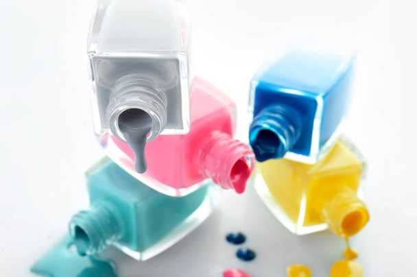 Open bottles of nail polishes on white background, closeup - Photo, Image