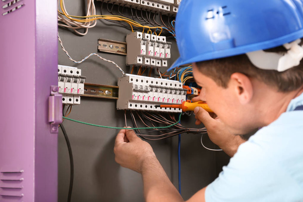 Electrician repairing distribution board indoors - Photo, Image