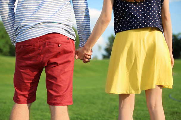Young couple walking in park on sunny day - Foto, imagen