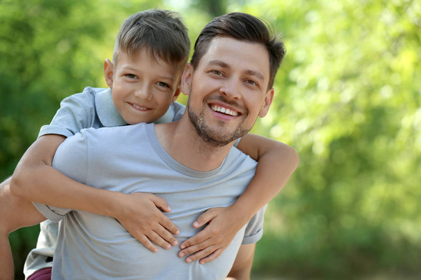 Ευτυχισμένος άνθρωπος με τον μικρό γιο του στο πάρκο - Φωτογραφία, εικόνα