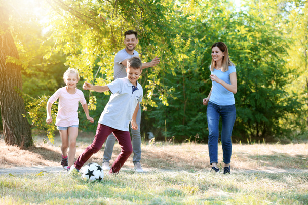 ευτυχισμένη οικογένεια παίζει ποδόσφαιρο σε εξωτερικούς χώρους - Φωτογραφία, εικόνα