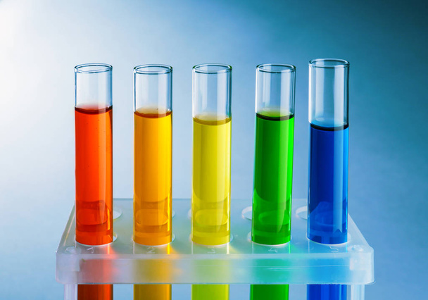 Test tubes with colorful liquids in holder on light background - Foto, immagini