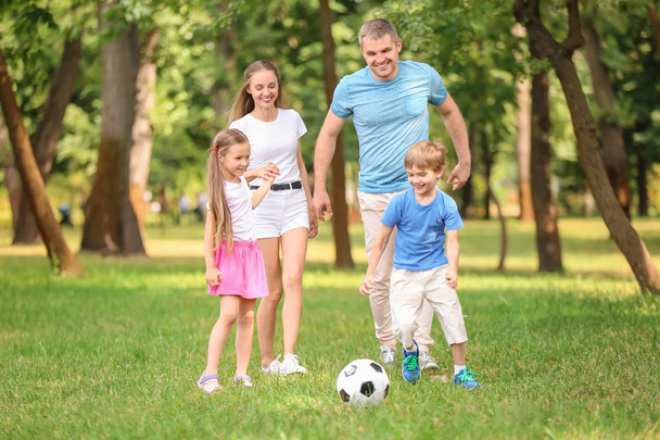 Ευτυχισμένη οικογένεια, παίζοντας ποδόσφαιρο στο πάρκο θερινή ημέρα - Φωτογραφία, εικόνα