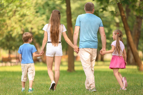 緑豊かな公園を一緒に歩いて幸せな家族 - 写真・画像