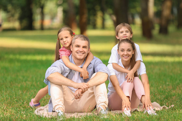 glückliche Familie ruht auf Plaid im Park - Foto, Bild