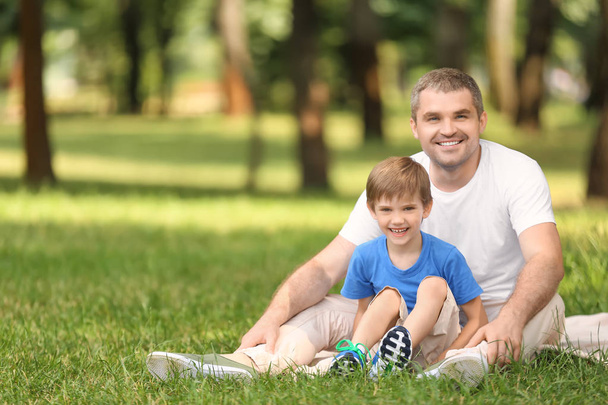 Onnellinen isä poika lepää ruudullinen vihreässä puistossa
 - Valokuva, kuva