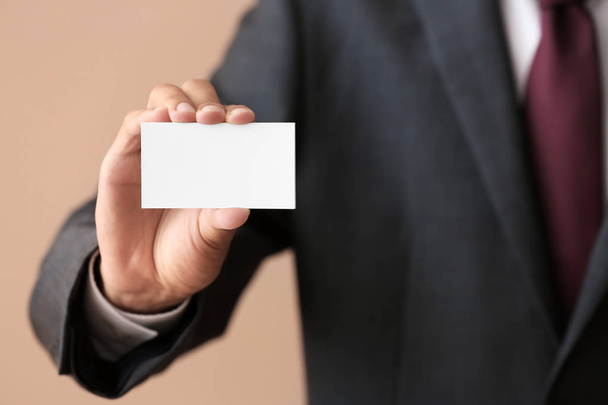 Man with business card on color background, closeup - Photo, Image