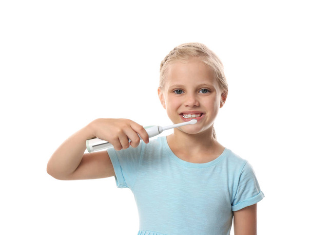 Cute little girl brushing teeth on white background - Foto, Imagen
