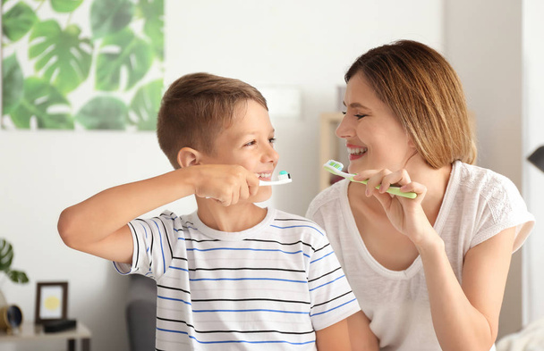 Женщина и ее маленький сын чистят зубы дома
 - Фото, изображение