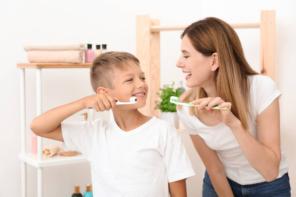 Маленький хлопчик і його мати чистять зуби у ванній
 - Фото, зображення