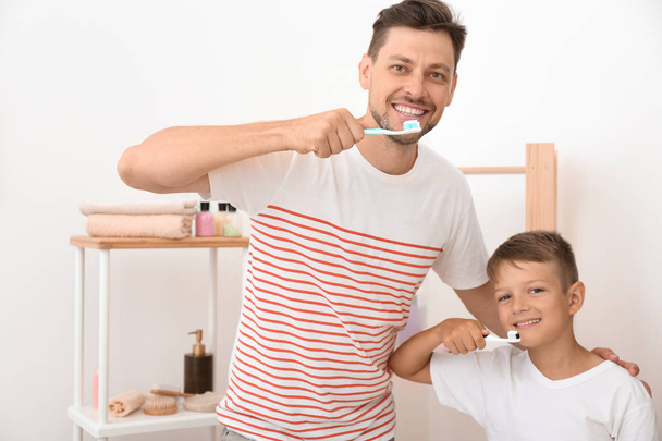 Kisfiú és apja fogmosás a fürdőszobában - Fotó, kép
