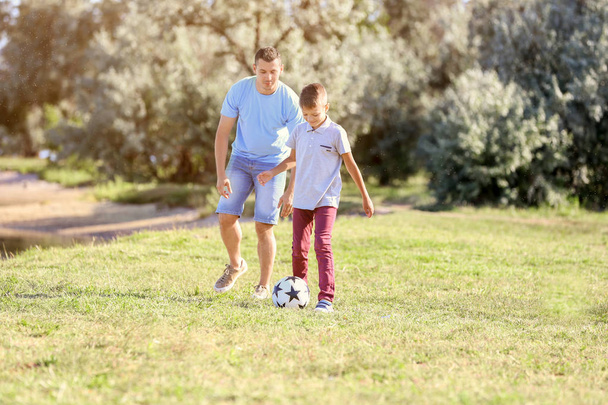 Padre con hijo jugando al fútbol al aire libre
 - Foto, imagen