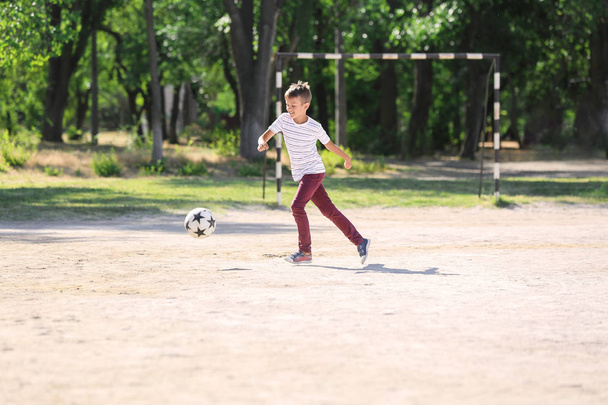 Menino jogando futebol em campo de futebol
 - Foto, Imagem