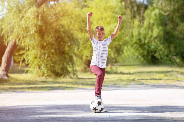 Menino jogando futebol ao ar livre
 - Foto, Imagem