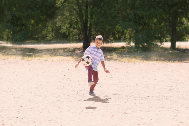 Mały chłopiec gry piłka nożna na zewnątrz - Zdjęcie, obraz
