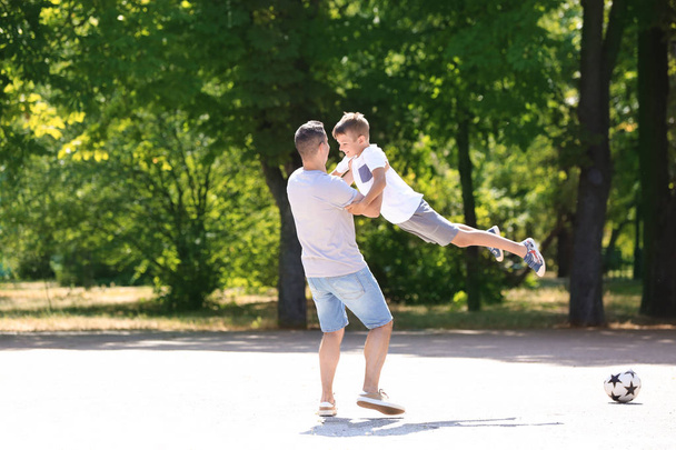 Little boy and his dad playing outdoors - Photo, image